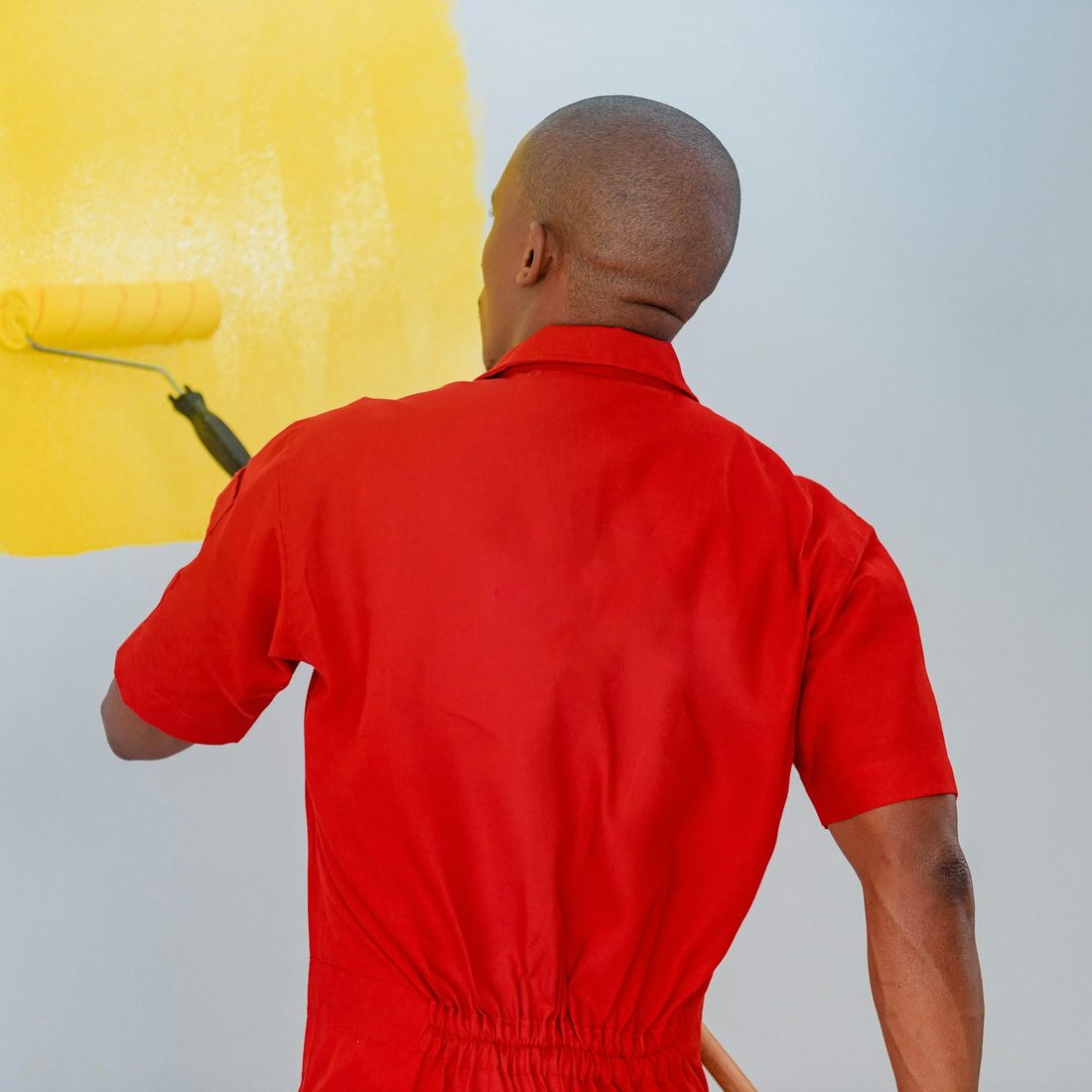 Painter rolling fresh paint onto an interior wall