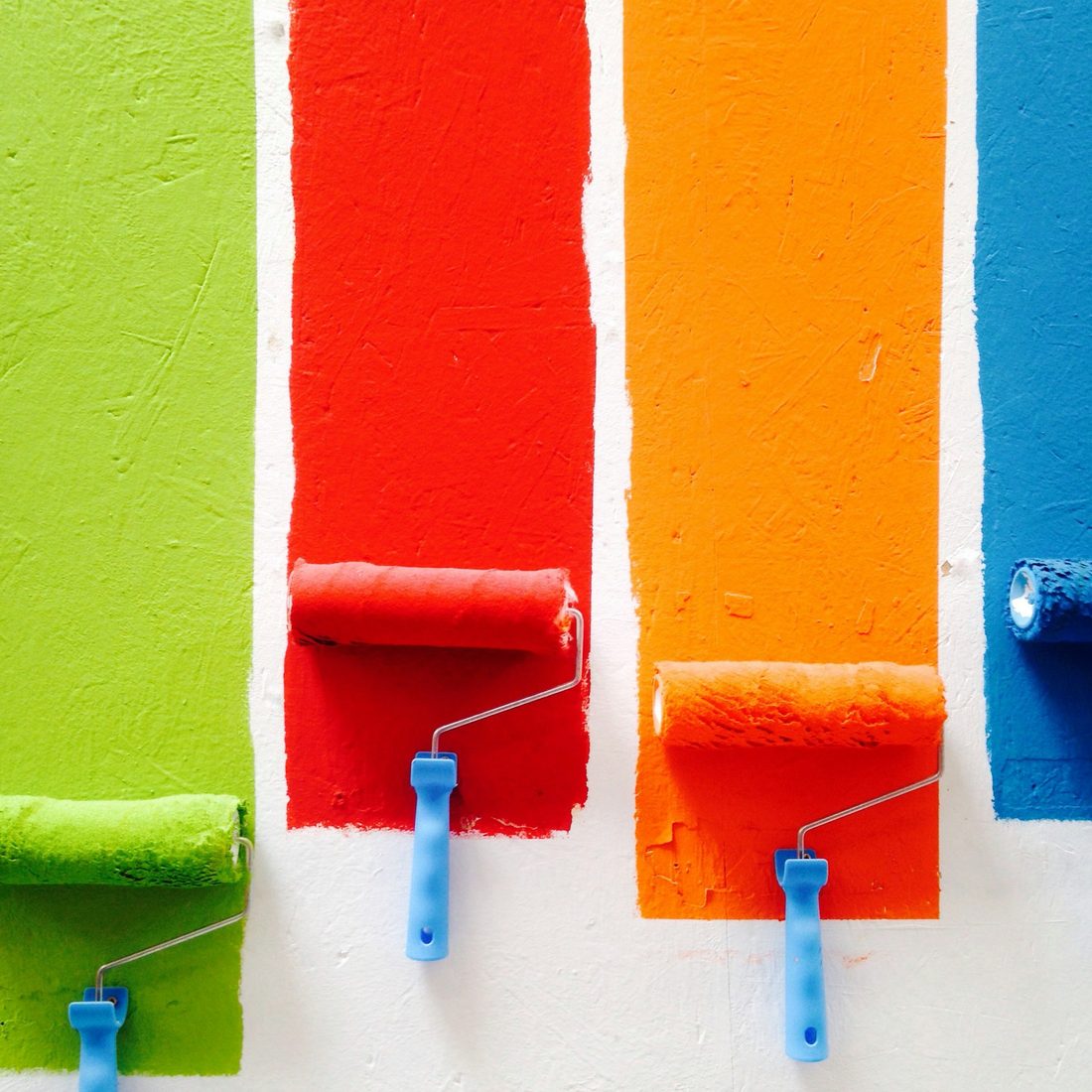 Rows of colourful paint rollers on a wall, illustrating colour and decorating options